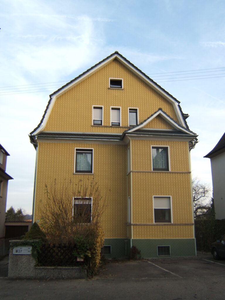 Gelbes Haus mit grünem Sockel.