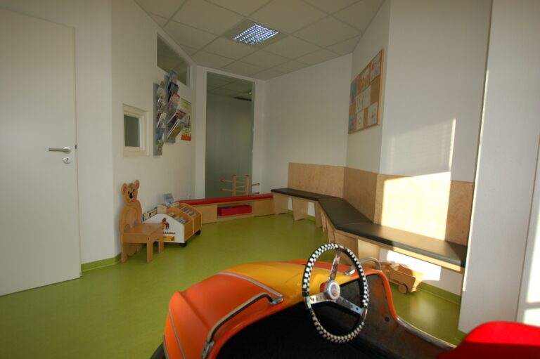 Kinderwartezimmer, Spielzeugauto, Bücherregal, Zeichnungen.