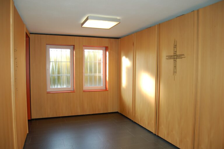 Heller Raum, Holzwände, modernes Kreuz.